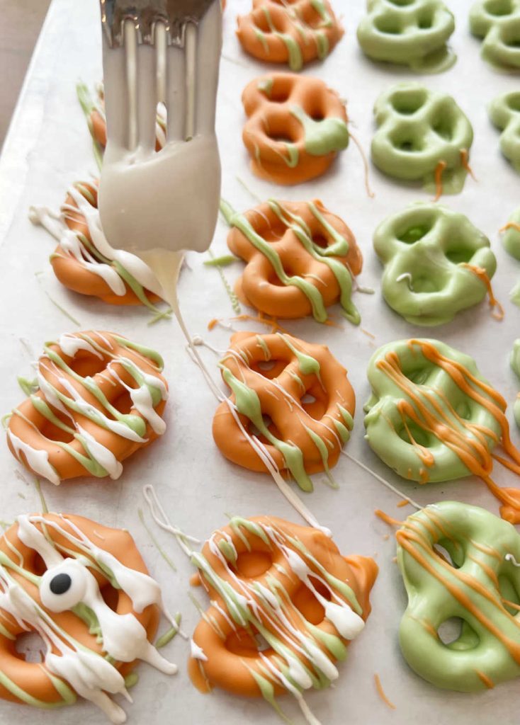 drizzle melted candy coating over mini pretzels with fork