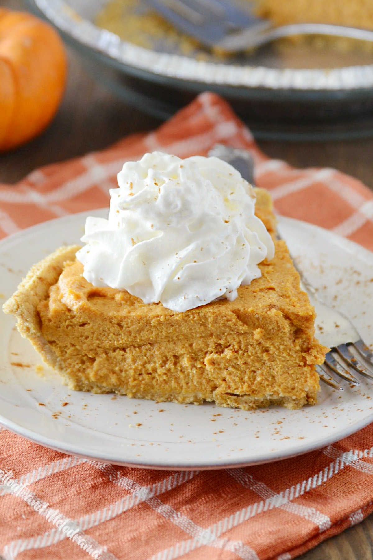 no bake pumpkin pie slice with whipped cream on plate