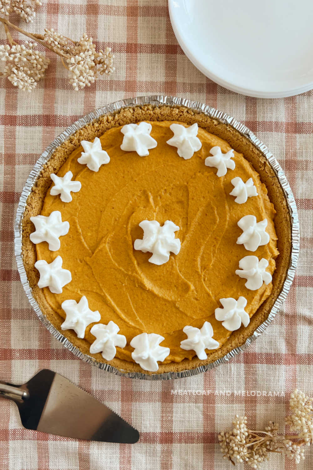 no bake pumpkin cheesecake pie with cream cheese in graham cracker crust with whipped cream