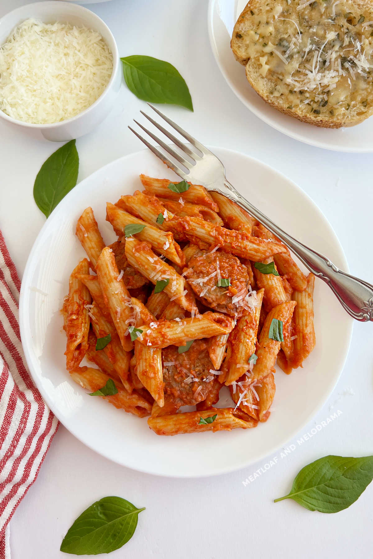 plate of penne alla vodka with Italian sausage and garlic bread