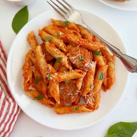 penne alla vodka with Italian sausage and fresh basil on a plate