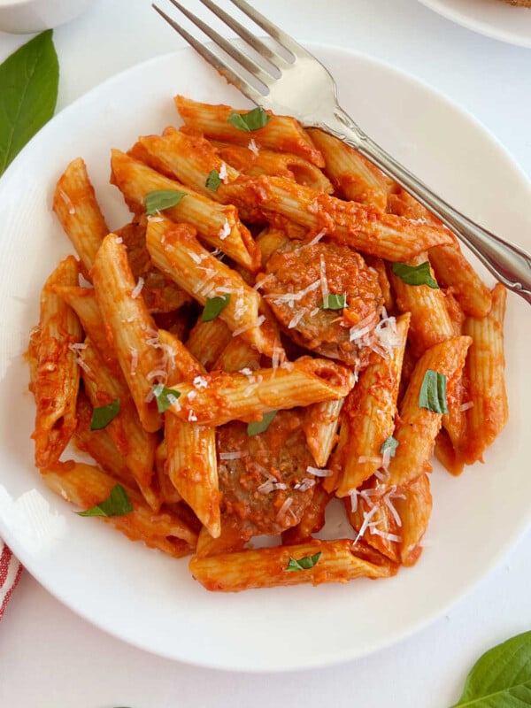 penne alla vodka with Italian sausage and fresh basil on a plate