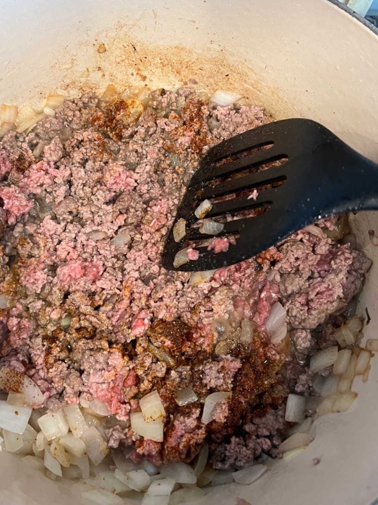 brown ground beef with onions in dutch oven