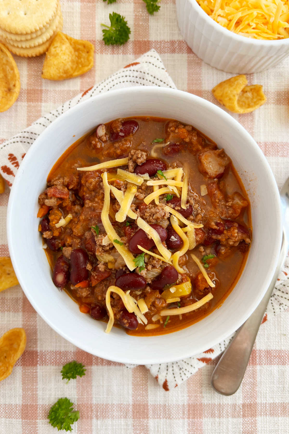 bowl of mild chili with ground beef and kidney beans and cheese cooked on stovetop