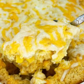 jiffy corn casserole (corn pudding) with cheese on serving spoon