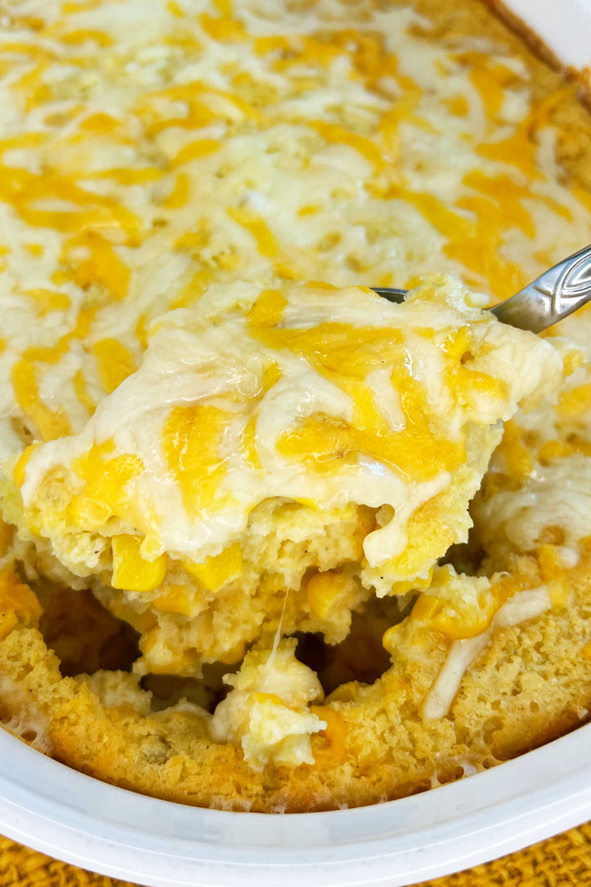 jiffy corn casserole (corn pudding) with cheese, sour cream and green chiles on serving spoon