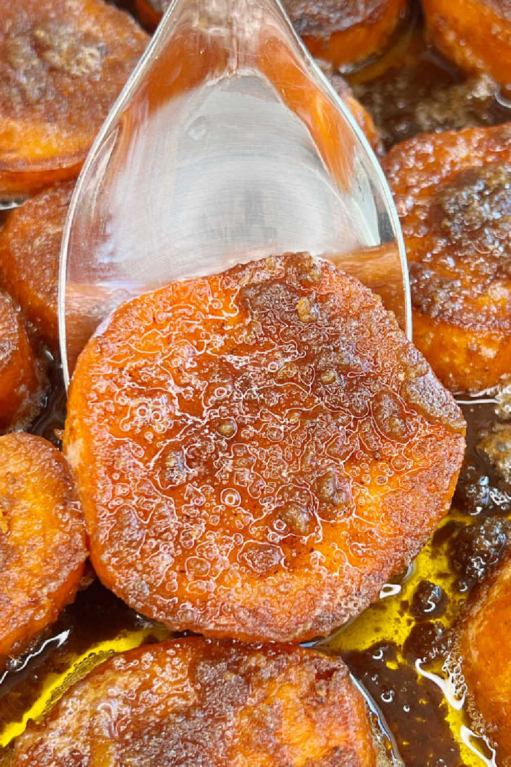candied yams with brown sugar on serving spoon