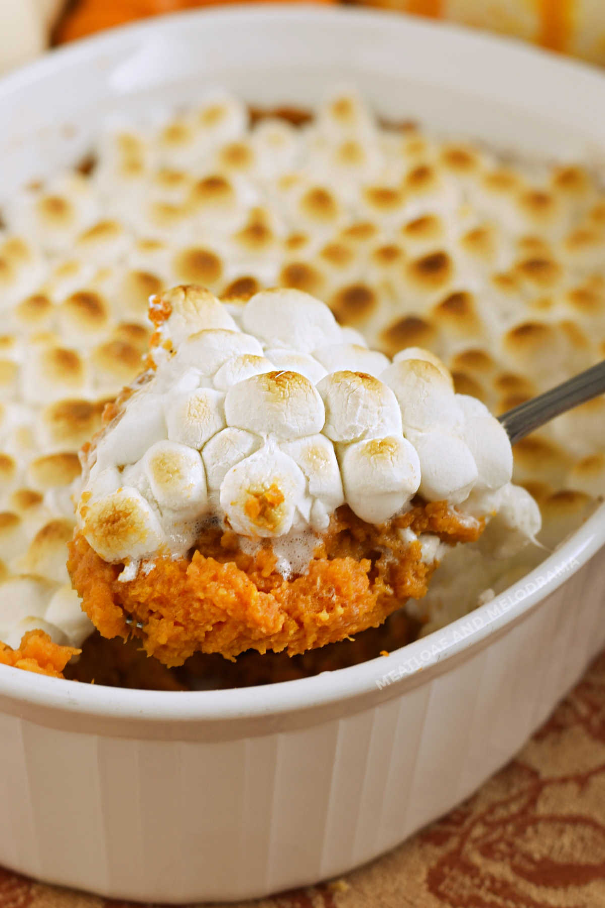 sweet potato casserole with marshmallows on a serving spoon