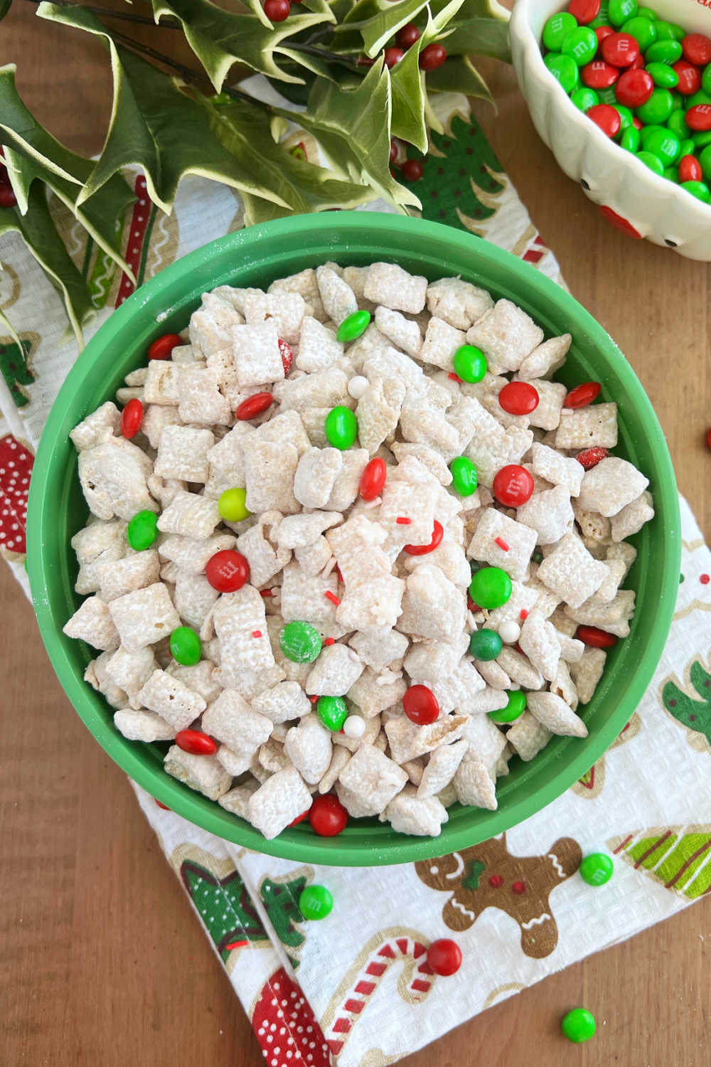 white chocolate puppy chow with sprinkles and Christmas m and ms candies in bowl