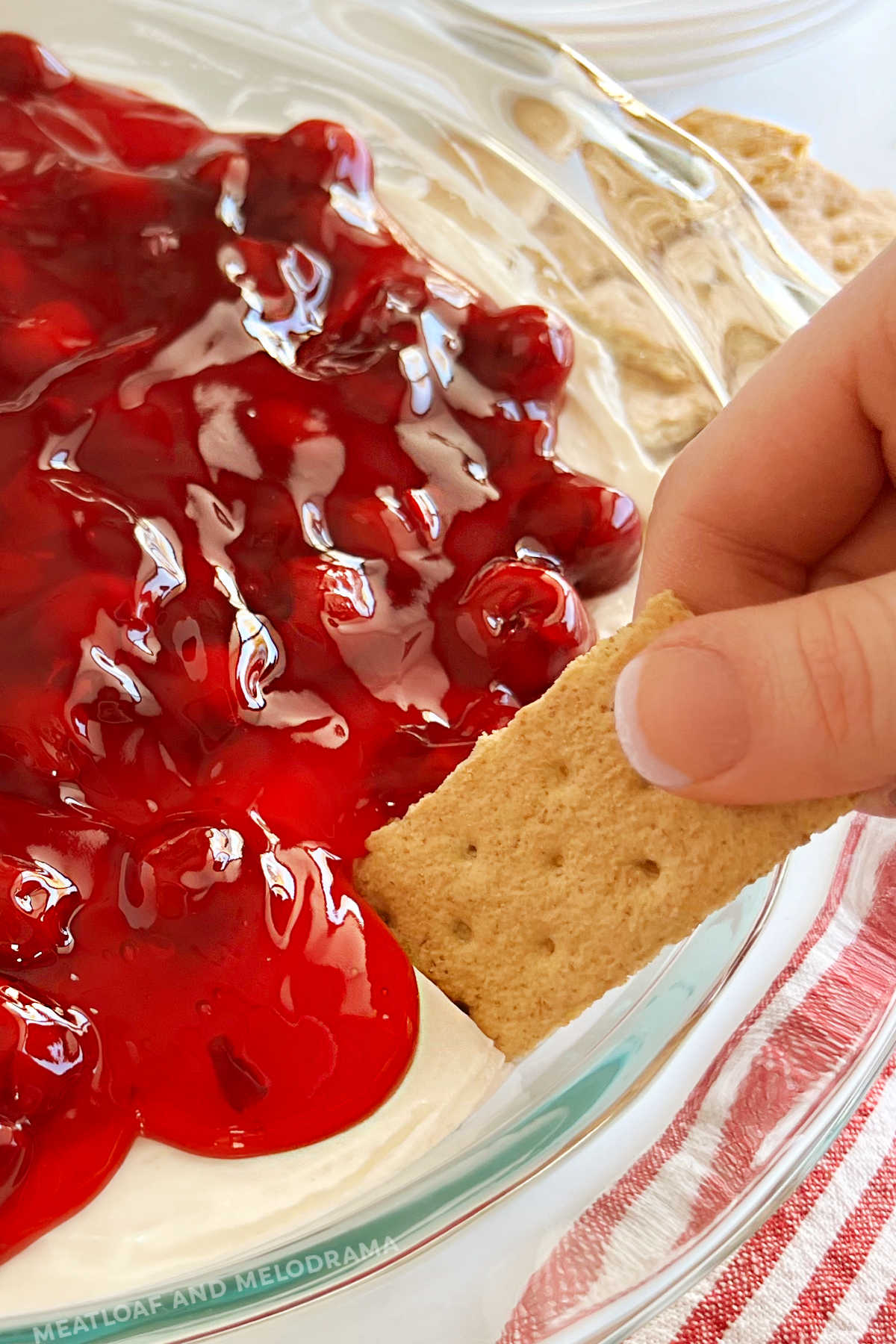 dip graham cracker into cherry cheesecake dip