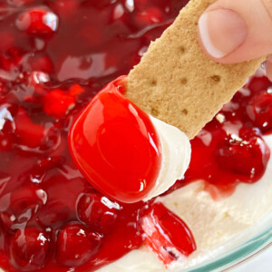 cherry cheesecake dip with pie filling on a graham cracker