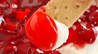 cherry cheesecake dip with pie filling on a graham cracker