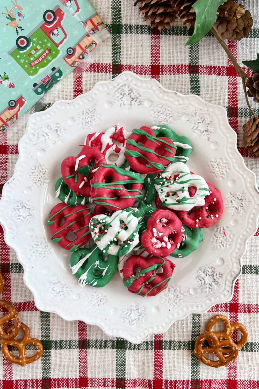 chocolate covered pretzels for Christmas with candy sprinkles on plate