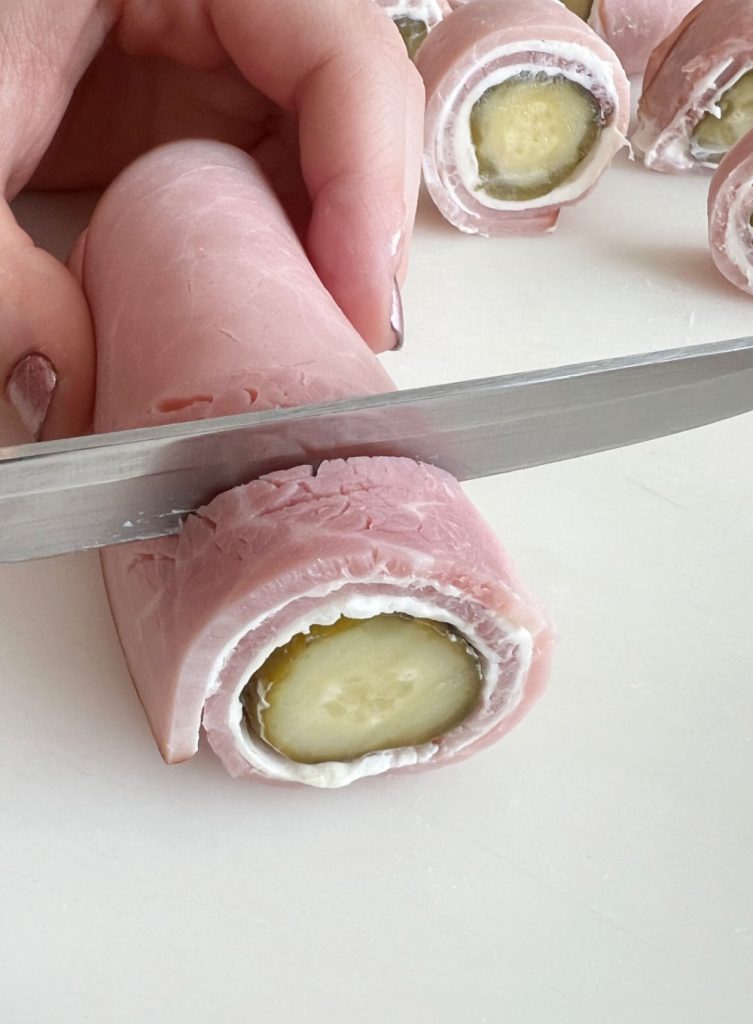slice ham roll ups into rounds with knife