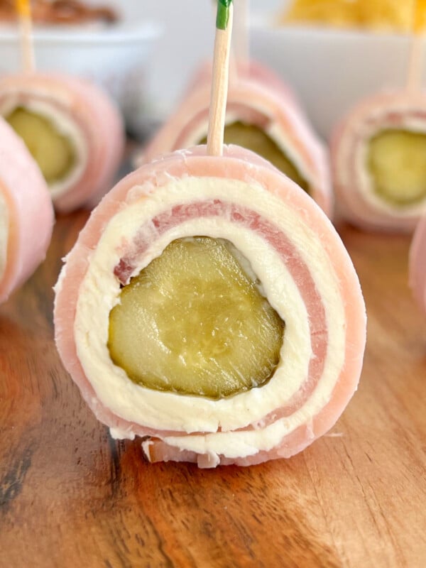 ham pickle roll ups with cream cheese on charcuterie board