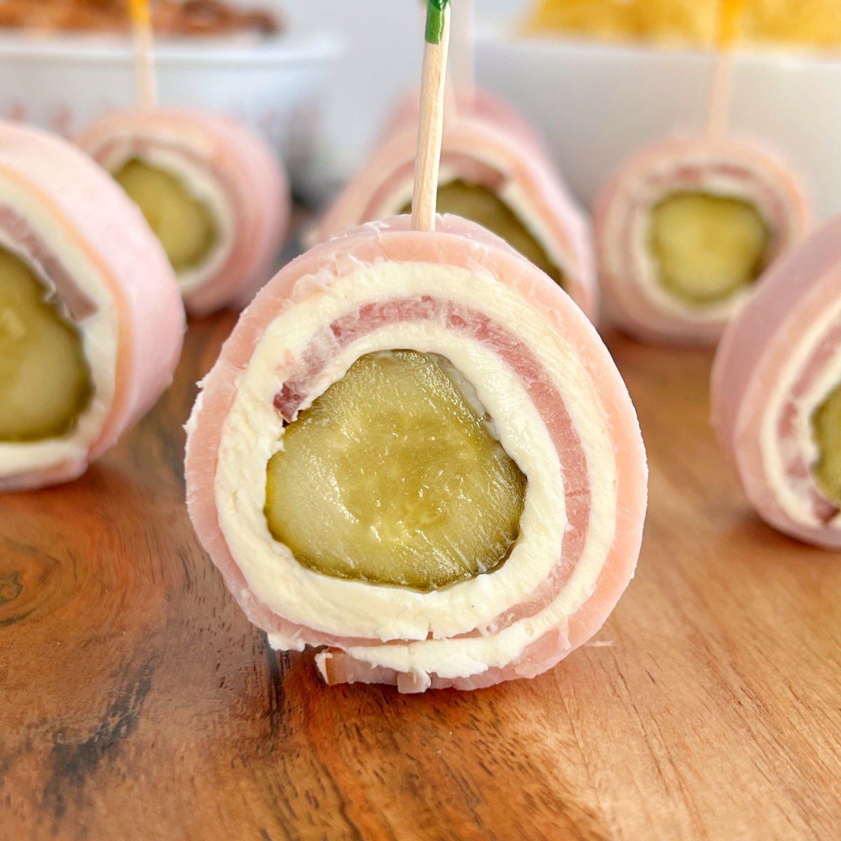 ham pickle roll ups with cream cheese on charcuterie board