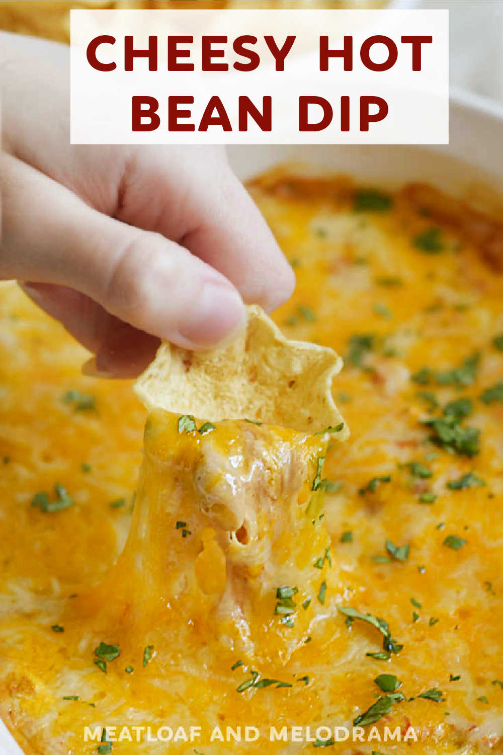Cheesy Hot Bean Dip with cream cheese, refried beans, sour cream, salsa and lots of cheese is a delicious appetizer the whole family loves. This delicious dip is perfect for dipping tortilla chips and Fritos and a real crowd pleaser at game day parties. via @meamel