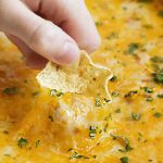 cream cheese bean dip with cheddar cheese on tostitos scoop tortilla chip