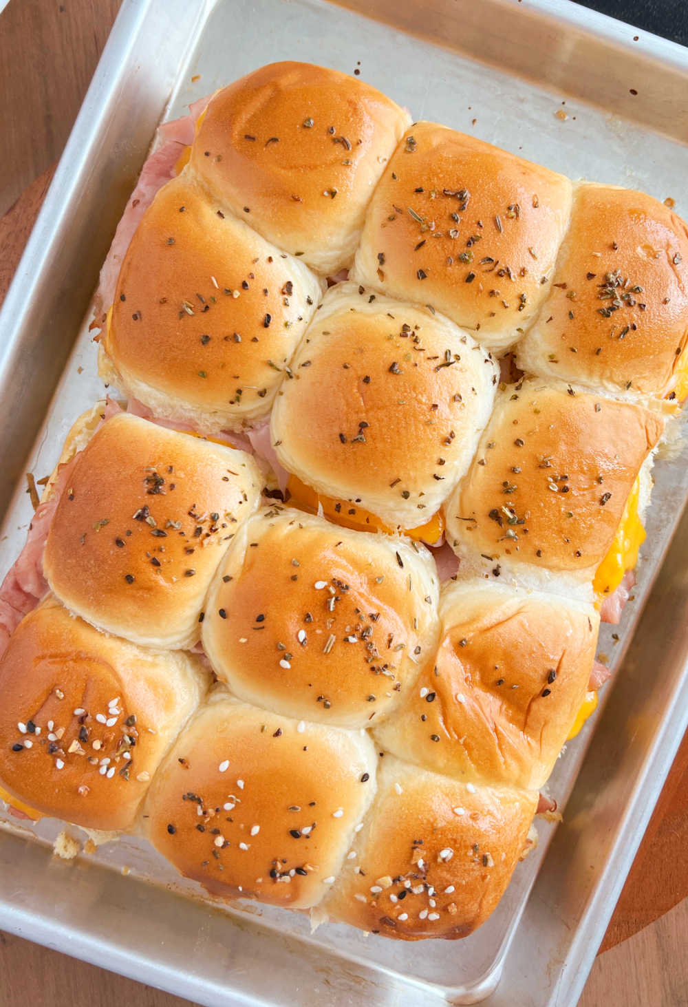 baked ham and cheese sliders made with leftover holiday ham on a baking sheet