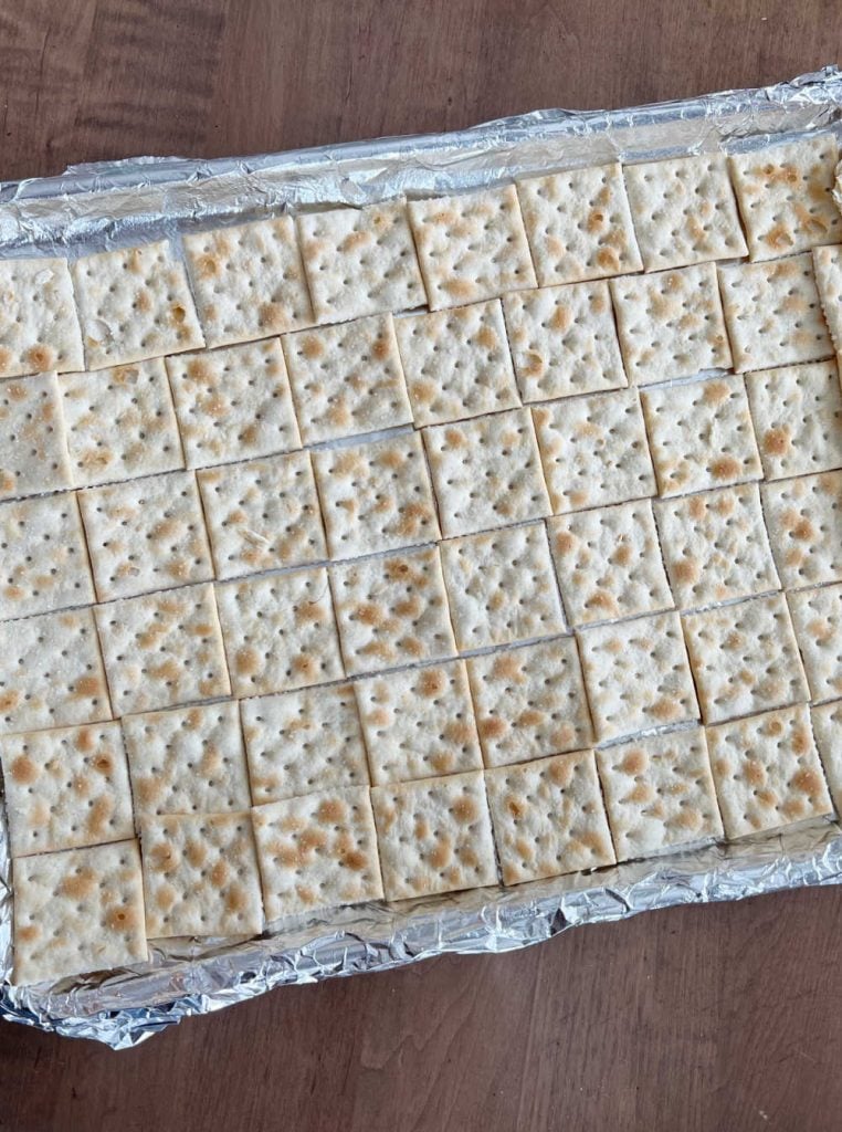 saltine crackers on a baking tray covered with foil