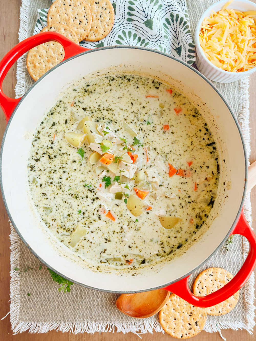 chicken potato soup with rotisserie chicken and carrots and cheese in red Dutch oven