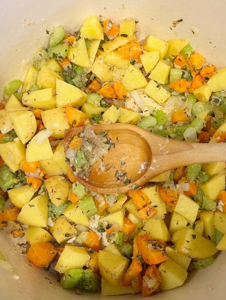 stir potatoes, herbs, carrots, celery, and onions with flour