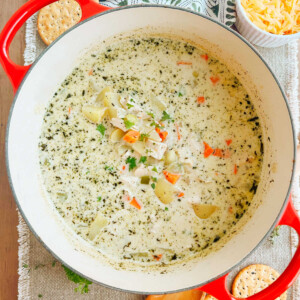 chicken potato soup with carrots and herbs in a Dutch oven