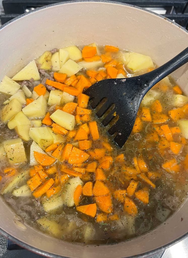 diced potatoes and carrots in beef soup