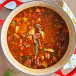 ground beef vegetable soup with green beans, potatoes and carrots in dutch oven