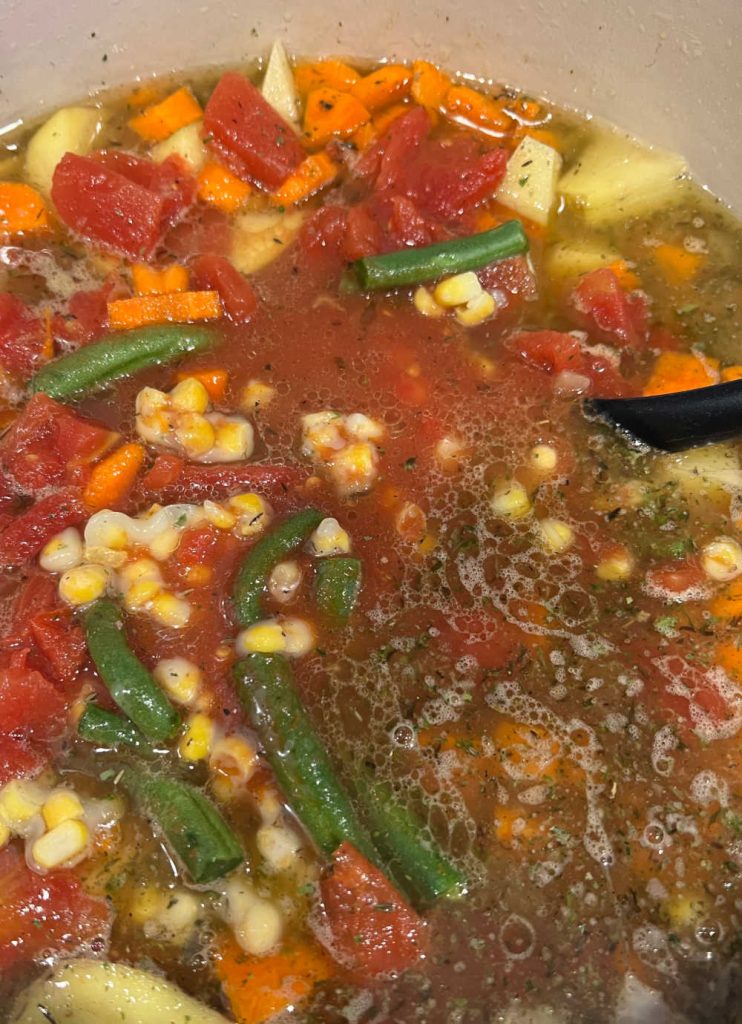 mix green beans and tomatoes into vegetable soup