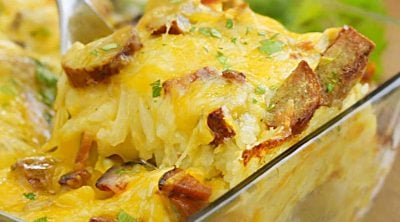 hashbrown breakfast casserole with hash brown potatoes and sausage on serving spoon