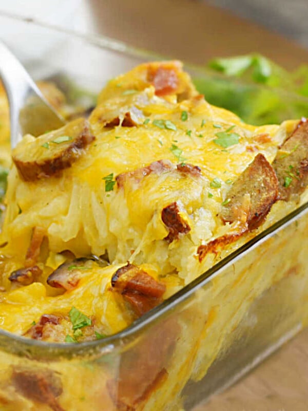 hashbrown breakfast casserole with hash brown potatoes and sausage on serving spoon
