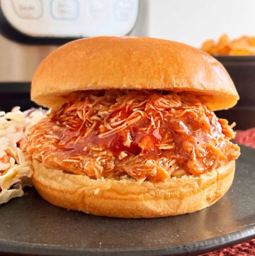 instant pot BBQ chicken in a pulled chicken sandwich on a plate