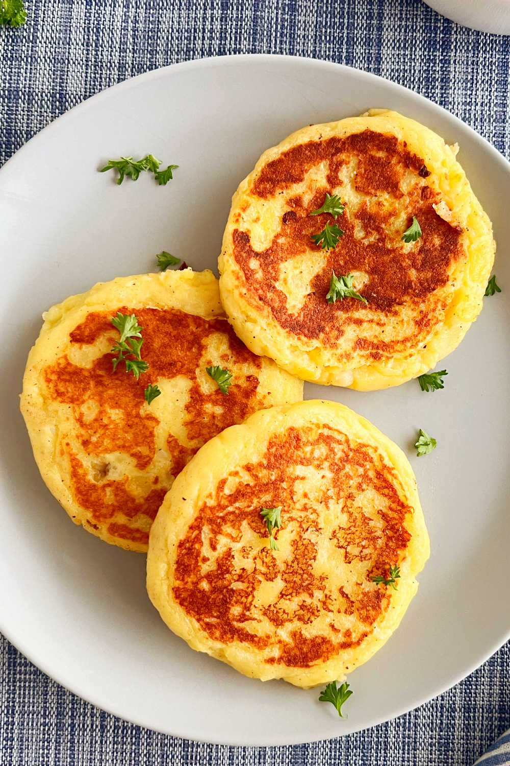 leftover mashed potato patties on a blue plate with parsley