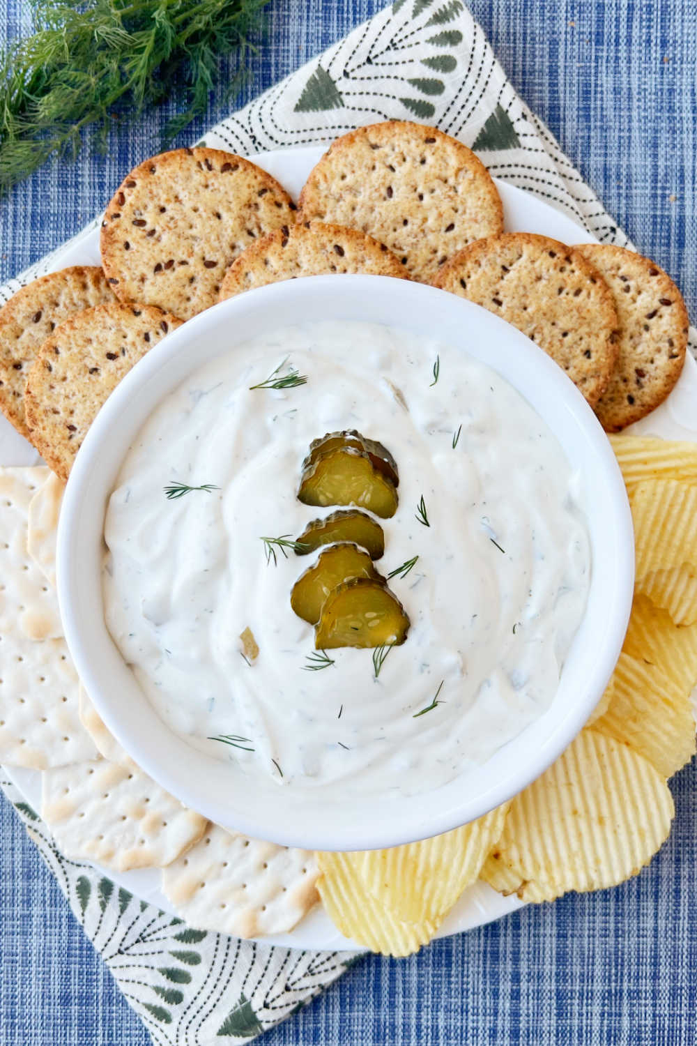dill pickle dip in serving bowl with sliced pickles on top