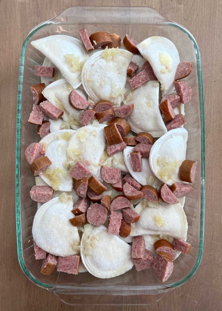 frozen pierogi with kielbasa slices and onions in casserole dish