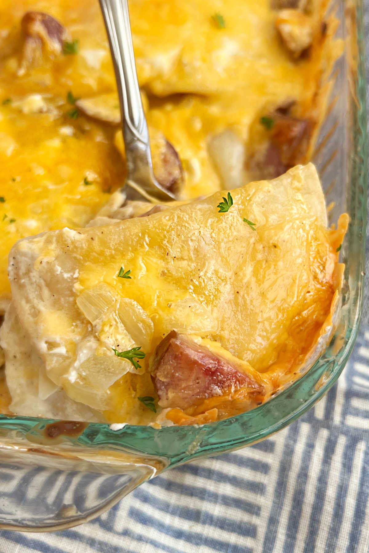 cheesy pierogi casserole with kielbasa on a serving spoon