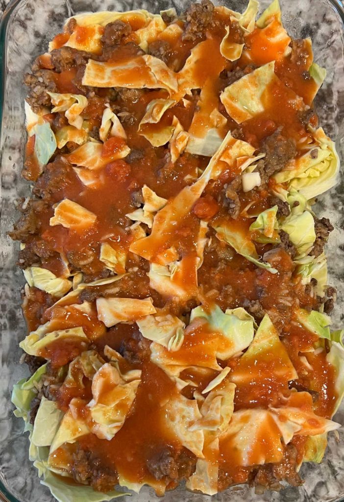 layer meat mixture and cabbage with tomato soup in casserole dish