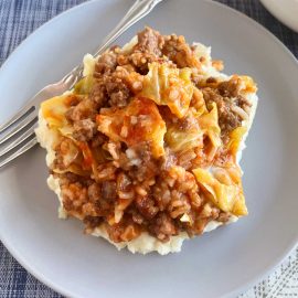 cabbage roll casserole on mashed potatoes on a blue plate
