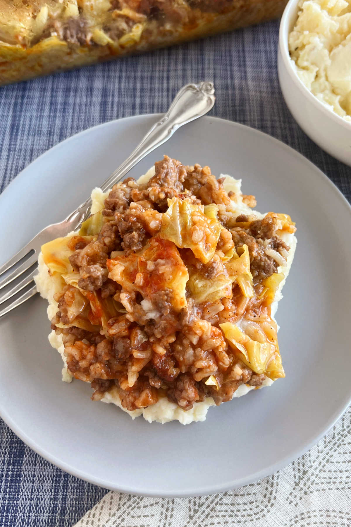 cabbage roll casserole, or lazy halupki, served with mashed potatoes on a blue plate