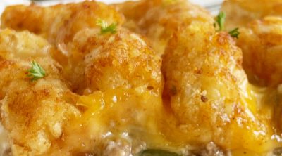cheesy tater tot casserole with hamburger meat and melted cheese on a plate