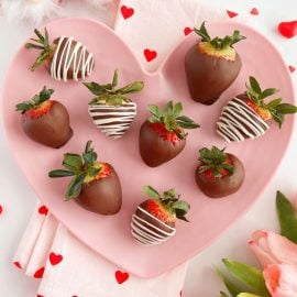 chocolate covered strawberries with white chocolate drizzle on pink heart plate - microwave.