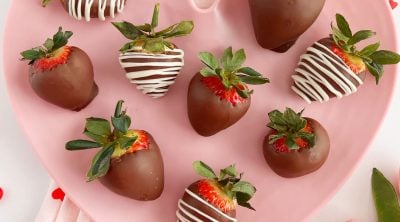 chocolate covered strawberries with white chocolate drizzle on pink heart plate - microwave.