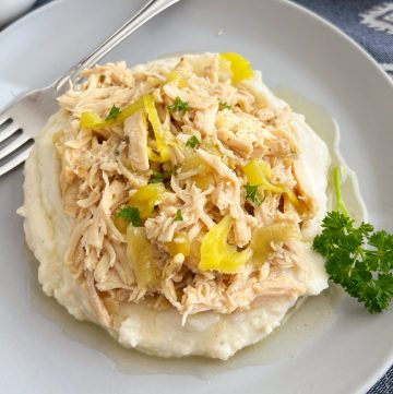 crock pot Mississippi chicken with pepperoncini peppers over mashed potatoes