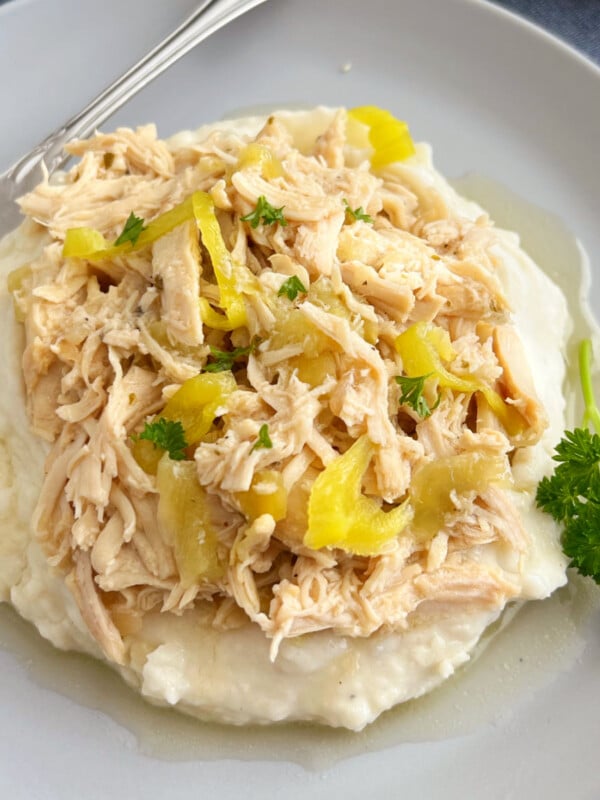 crock pot Mississippi chicken with pepperoncini peppers over mashed potatoes