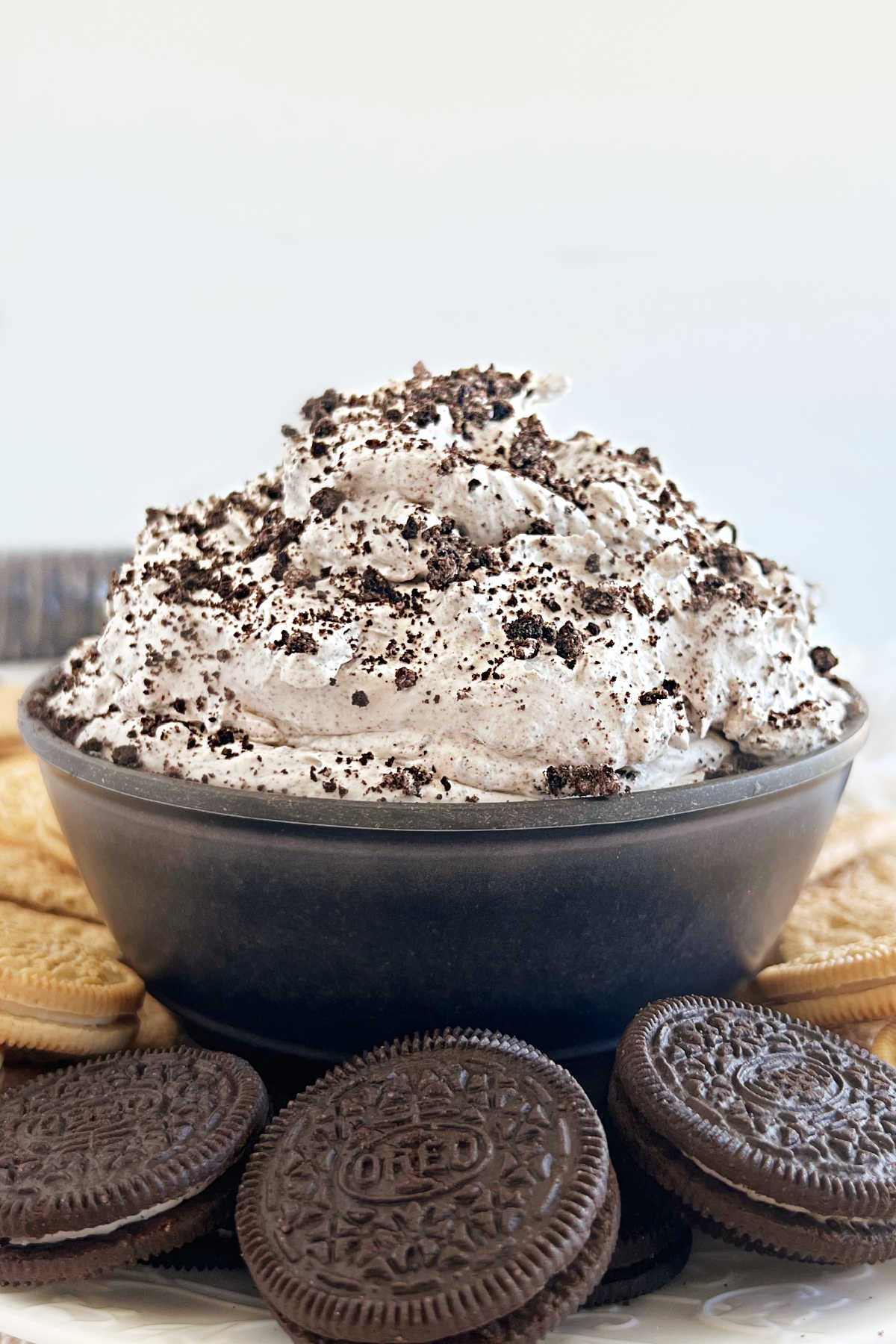 Oreo dip or cookies and cream dip with crushed oreos in a black serving bowl
