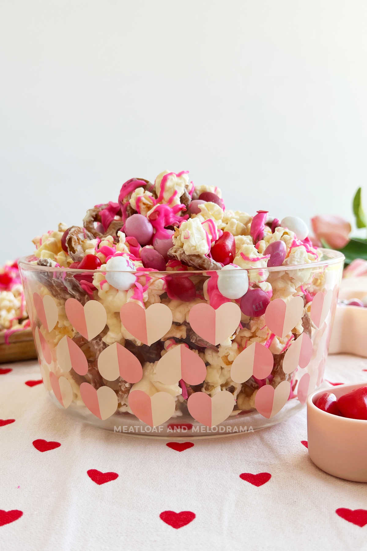 Valentine's day popcorn snack mix in a glass dish with hearts