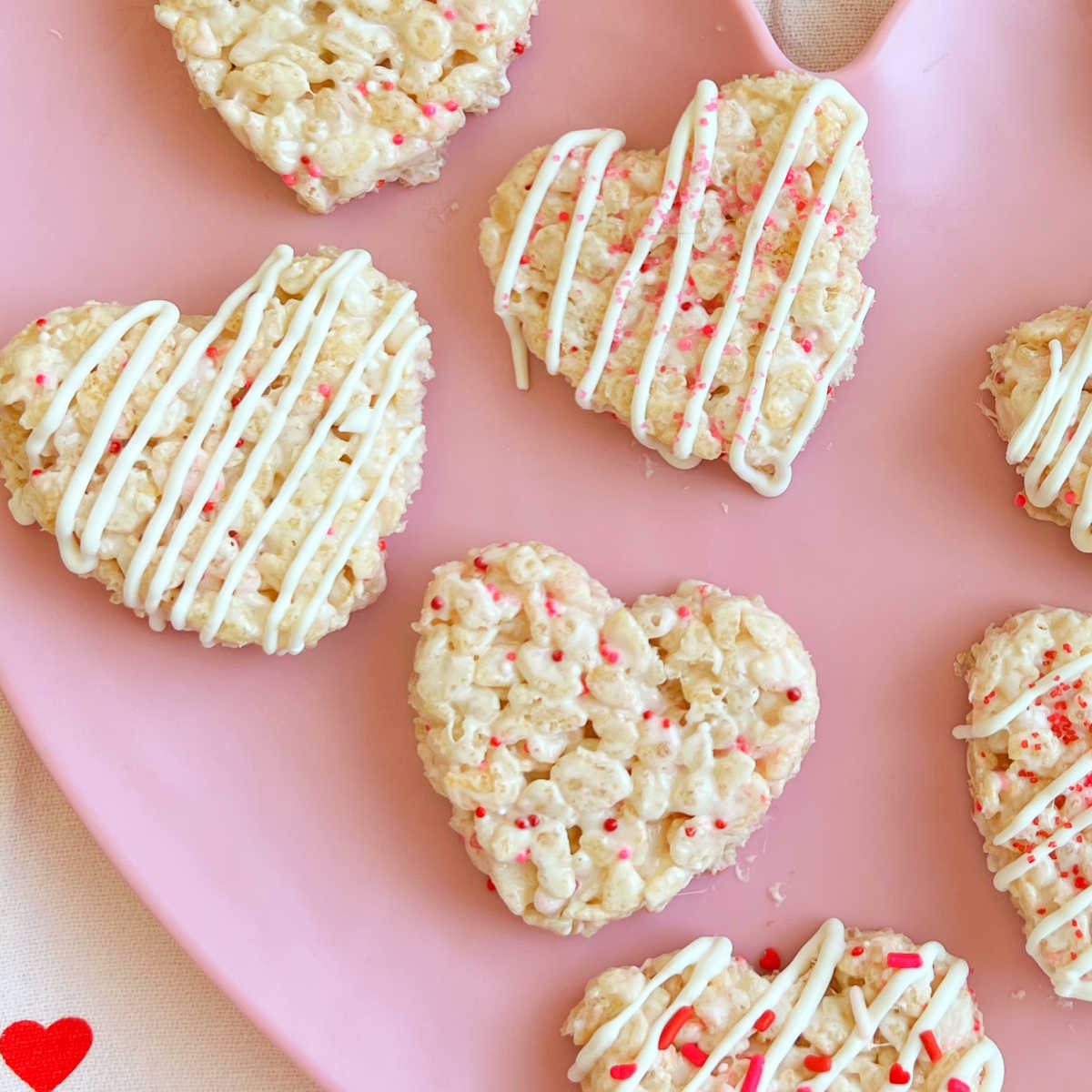 heart shaped Valentine Rice Krispie treats with sprinkles on a pink plate