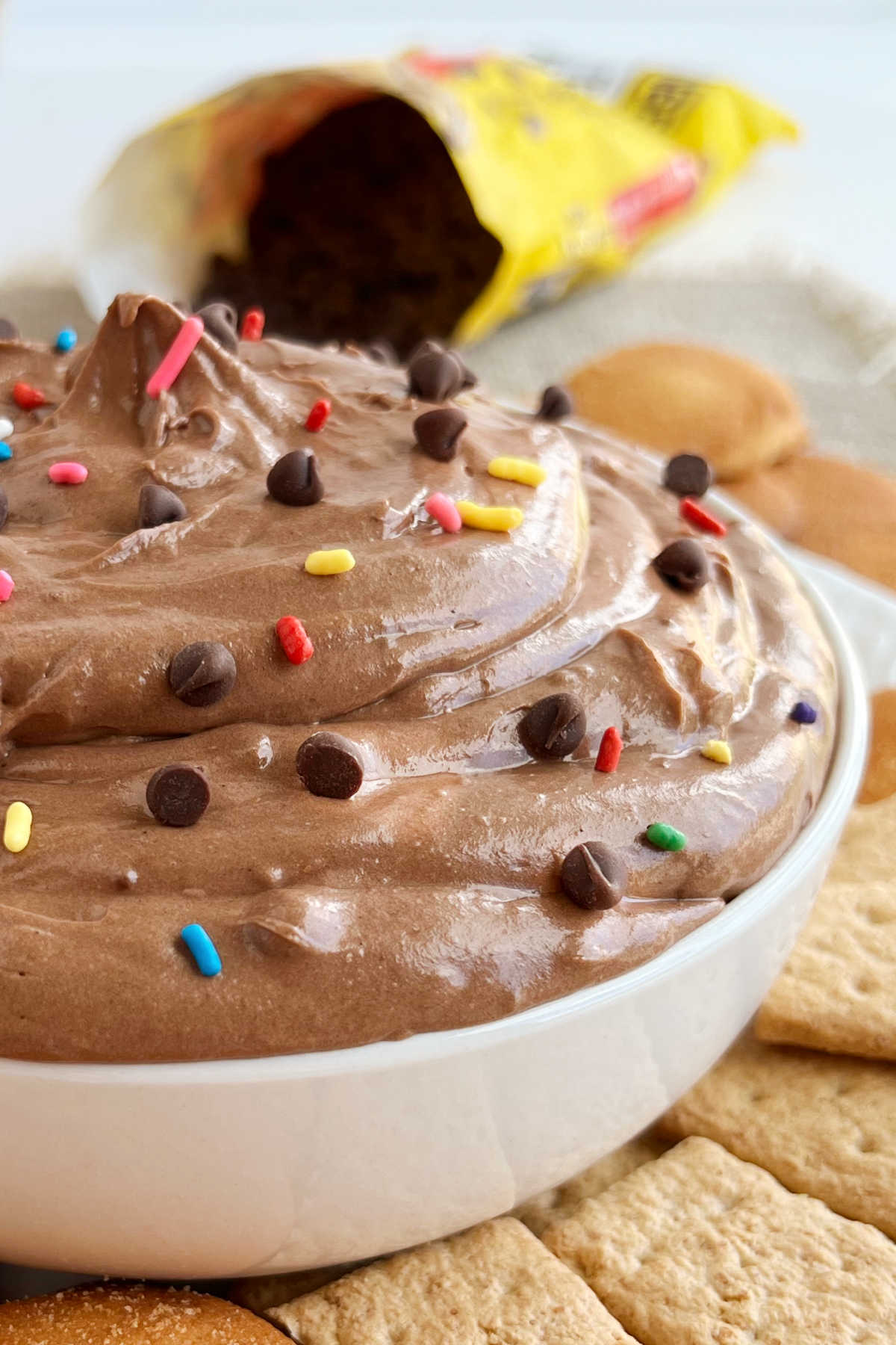 bowl of creamy brownie batter dip with chocolate chips and sprinkles