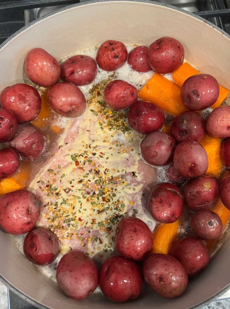 corned beef in dutch oven with beer, baby red potatoes and carrots